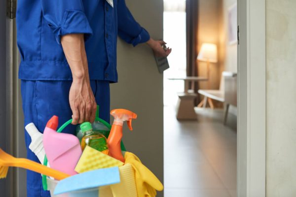 unrecognizable-cleaner-walking-into-hotel-room-with-tools-detergents (1) Zdjęcie mężczyzny trzymającego wiaderko ze środkami czystości - czyszczenie i pranie tapicerki
