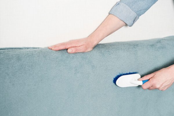 woman-brushing-textile Kobieta czyszcząca materiał - czyszczenie i pranie tapicerki
